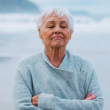 Imagen de una mujer mayor meditando frente al mar