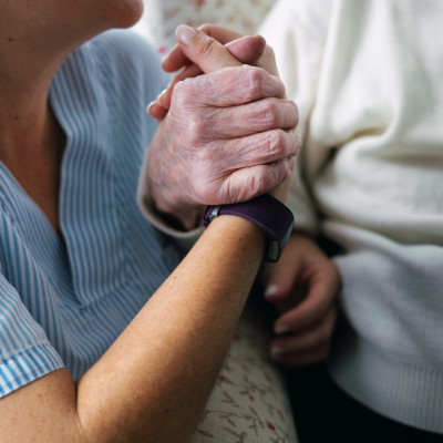 Una persona joven y una persona mayor se cogen de la mano